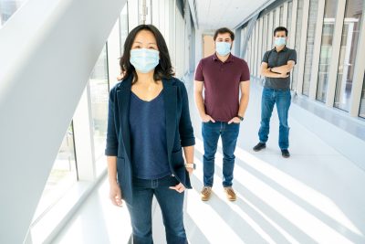 Pearl Chiu, Mark Orloff, and Brooks King-Casas wearing masks and socially distanced standing in hallway